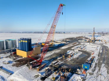 Picture shows the Elb X construction site from diagonally above. Snow lies on the surrounding fields. The silos of the specialised civil engineering department stand out in particular.