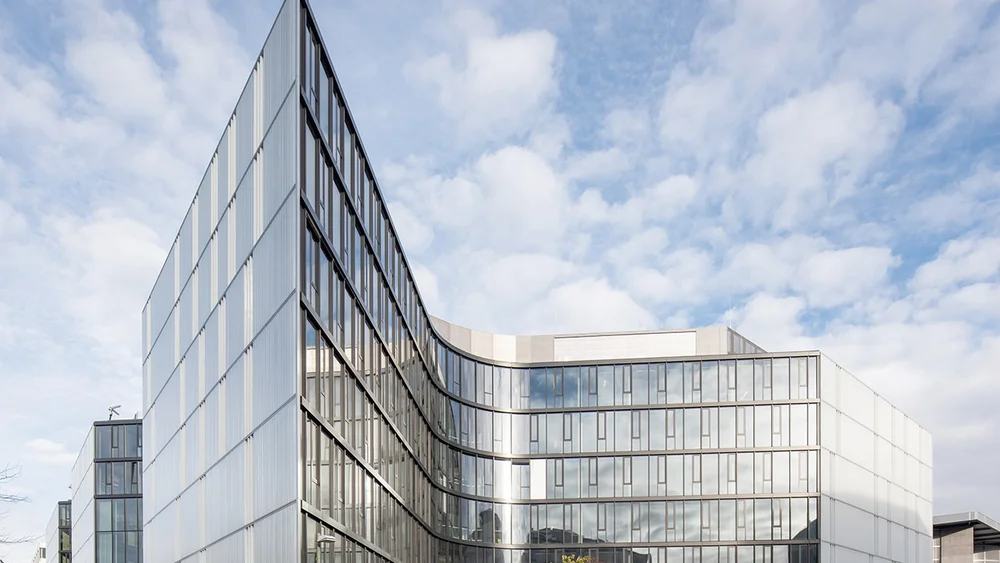 Bild zeigt das Bürogebäude von Zalando von außerhalb. Das Büro hat eine Glasfassade.