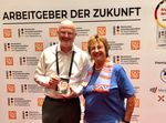 Udo Pauly steht neben Brigitte Zypries und hält den Arbeitgeber der Zukunft Award in seiner Hand