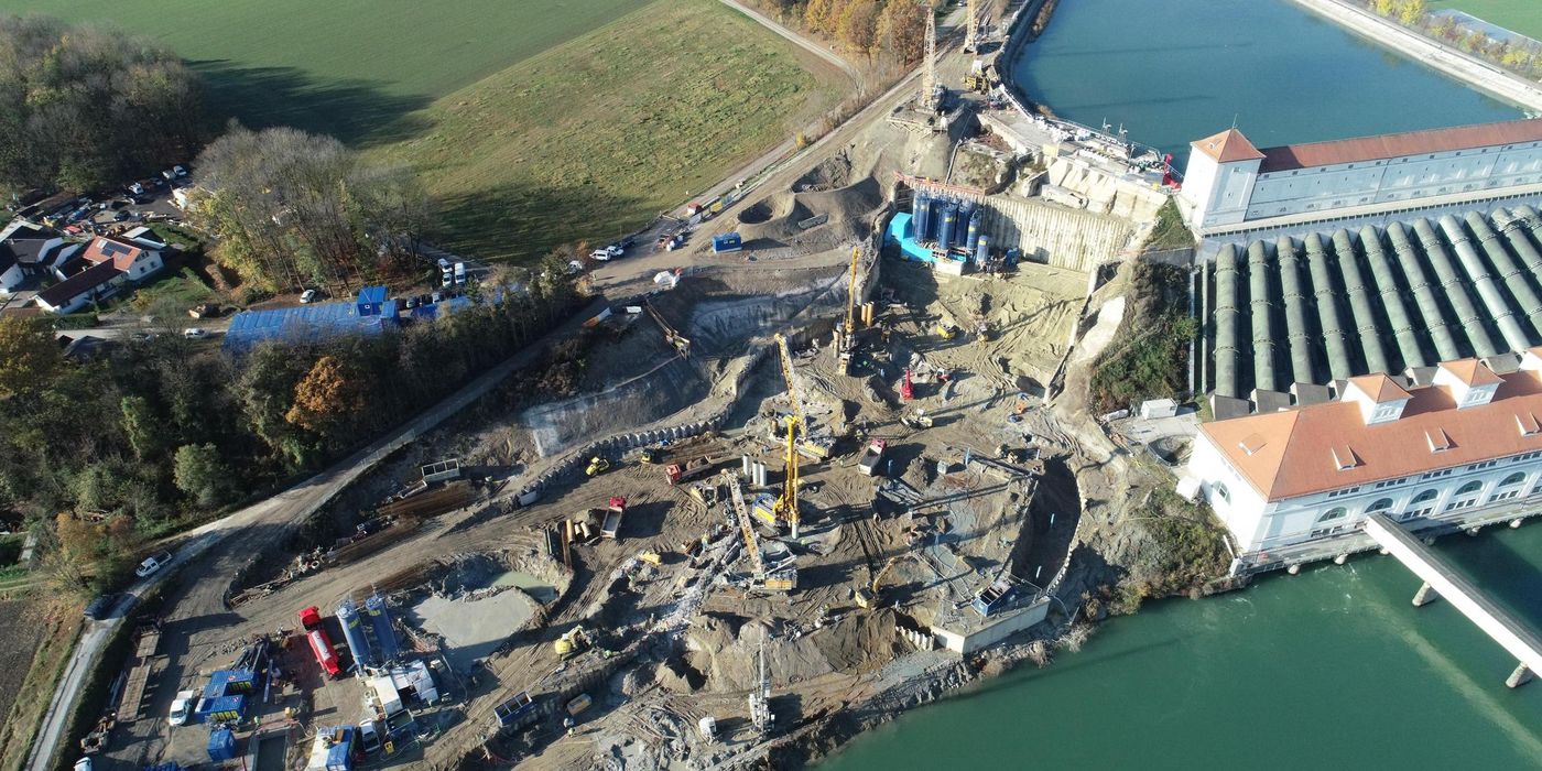 Overhead view of the construction. The historic power plant can be seen on the right of the image. The construction pit is being excavated to the left of it. 