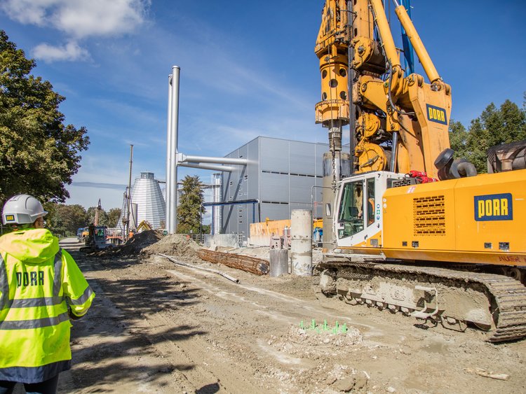 KlĂ€rwerk GroĂlappen, MĂŒnchen Bild zeigt einen Bauarbeiter der PORR neben einem BorhgerĂ€t.