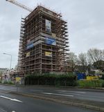 The picture shows the residential tower being remodelled by PORR. Scaffolding covers the building