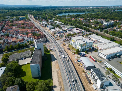 Drohnenaufnahme von dem Südschnellweg; man sieht die Verkehrsache von oben; im Hintergrund ist ein See;
