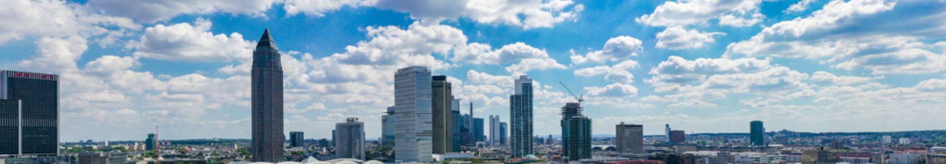 PORR Header Hochbau; man sieht die Skyline von Frankfurt am Tag; der Himmel ist blau aber einige Wolken ziehen durch die Stadt; man sieht mehrere Hochhäuder